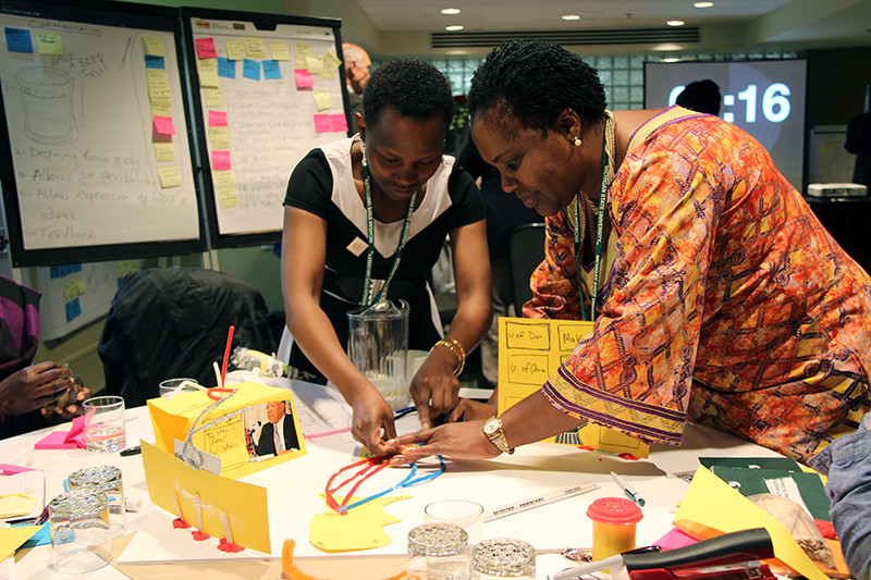 Two female African attendees working on a colorful illustration